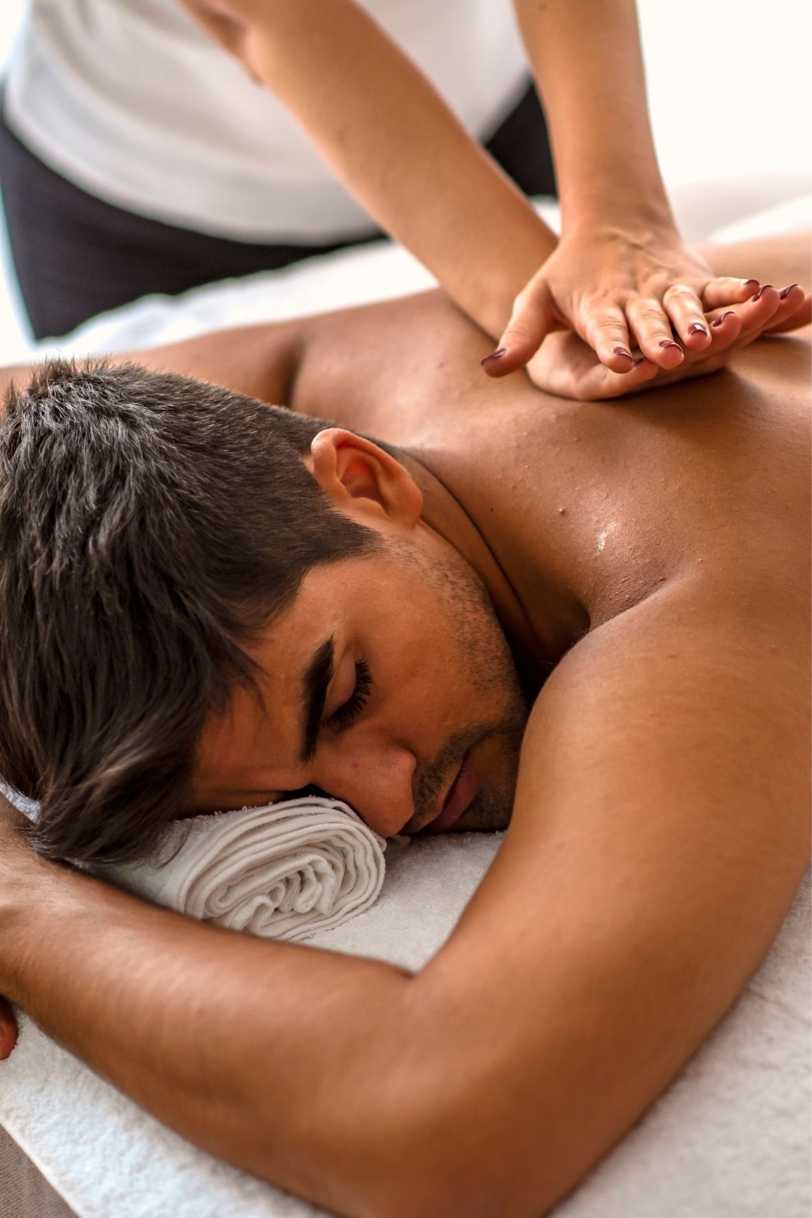 Table de massage recouverte d’un drap blanc dans un espace de massothérapie  à Trois-Rivières